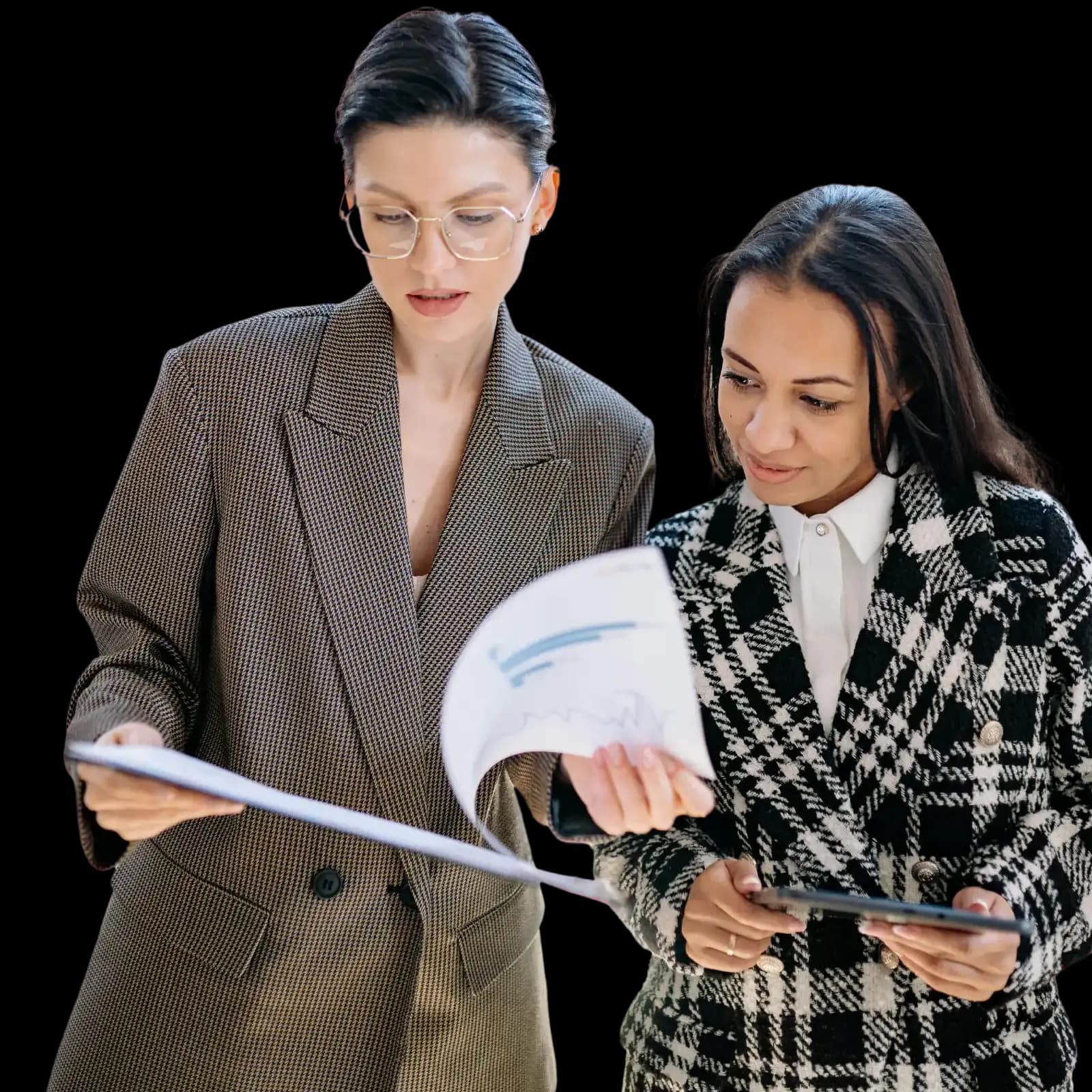 Two business professionals standing together, one reviewing paperwork and the other holding a tablet and looking at the documents, illustrating collaborative planning and document review for starting a nonprofit organization.