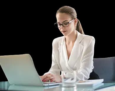 A business professional in formal attire sitting at a desk with a laptop, notebook, and glass of water—focused on reinstating a business online and ensuring compliance.